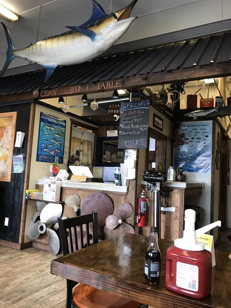Interior of Mohala’s with the hand-painted Ocean to Table sign and weathered-wood walls.